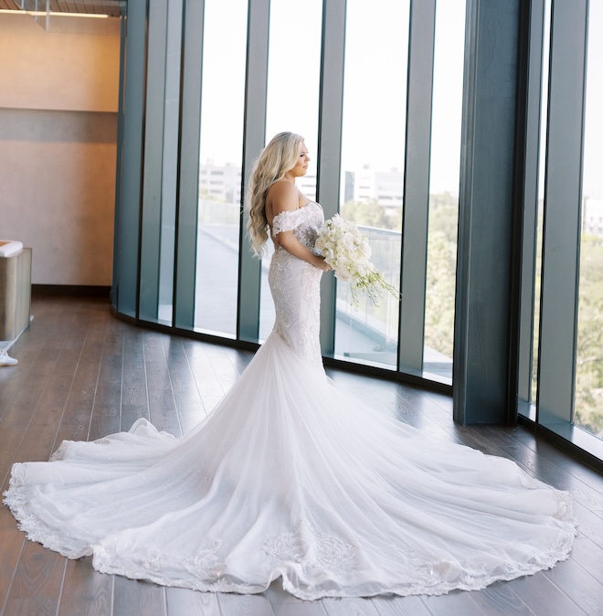 The bride looking out floor to ceiling windows in the Thompson Houston.