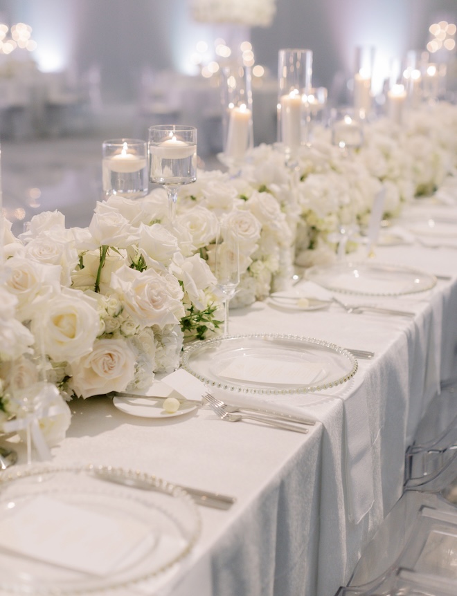 White florals lining the long reception table. 