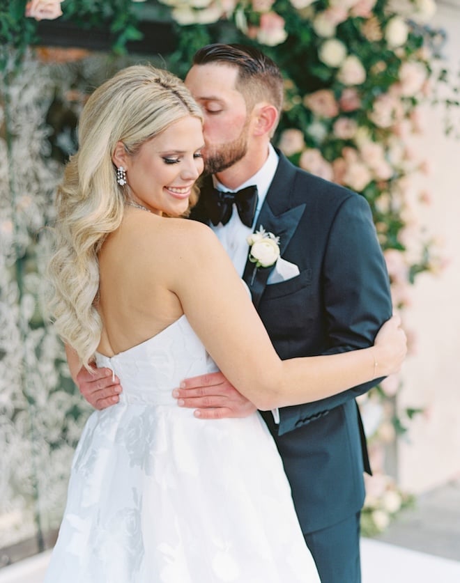 The groom kissing his bride on the cheek outside the Corinthian Houston. 