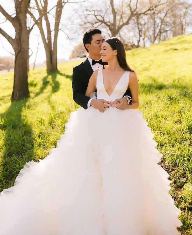 The groom kissing the bride's cheek outside at Hyatt Regency Lost Pines Resort & Spa. 