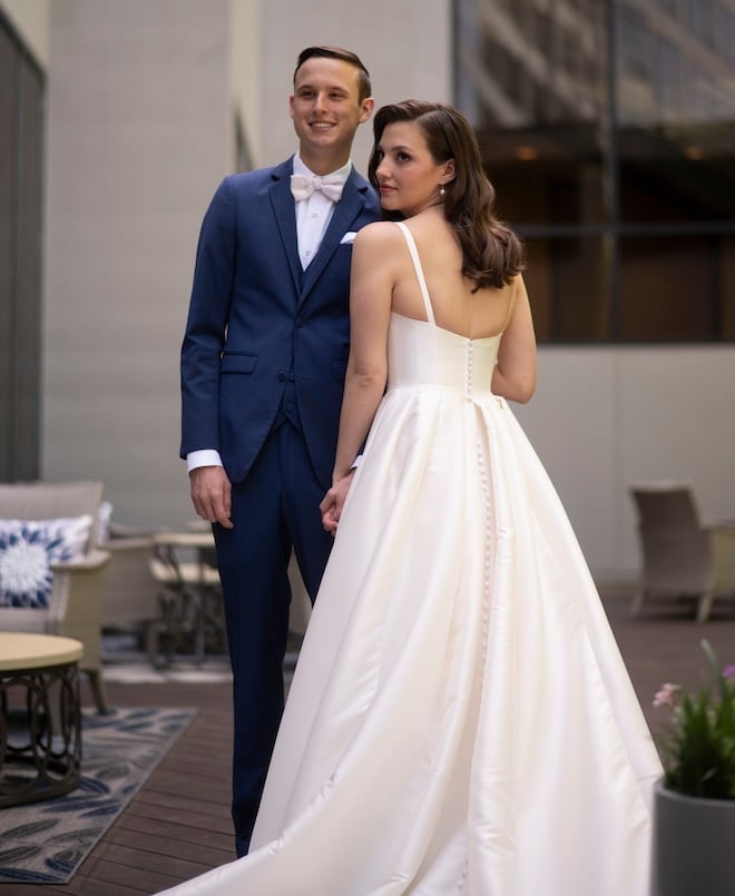 The bride and groom posing for the camera outside the Omni Houston Hotel. 