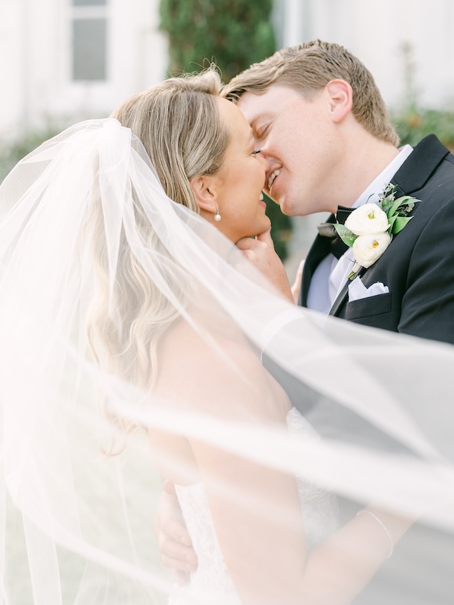 The bride and groom smiling as they are about to share a kiss. 