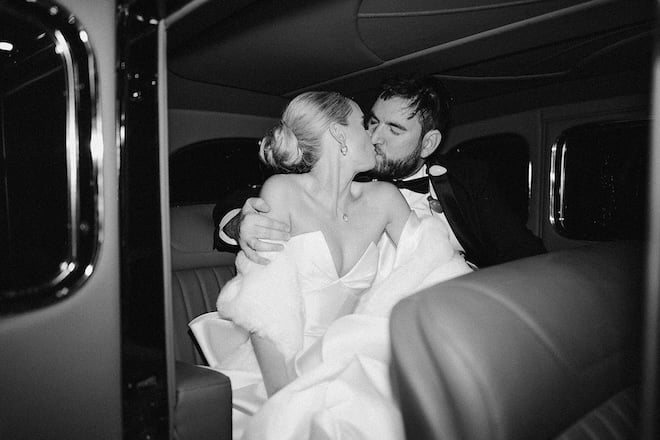 The bride and groom kissing in the getaway car. 