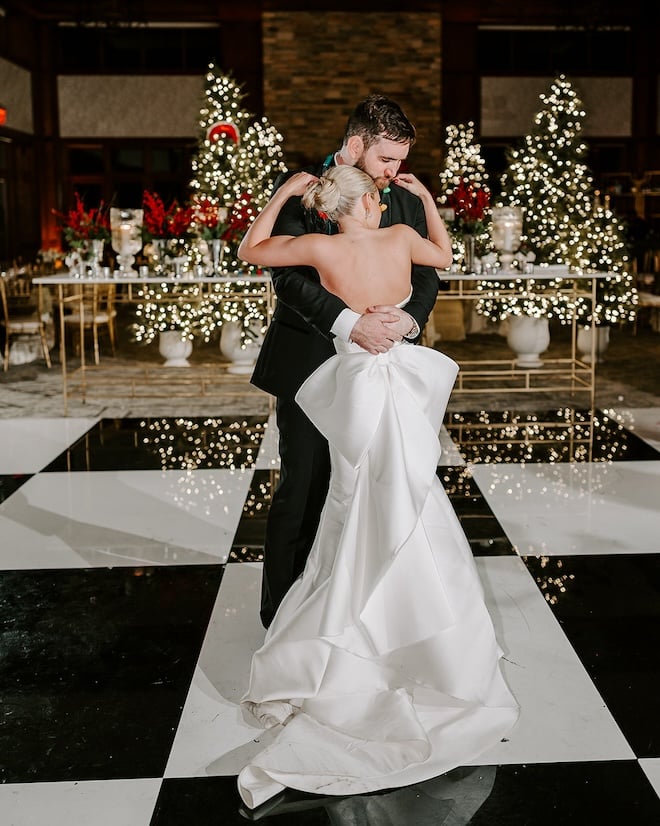 The bride and groom dancing on the black and white dance floor during their private dance. 