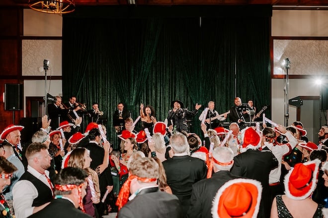 The guests wearing red cowboy hats dancing while the band performs. 