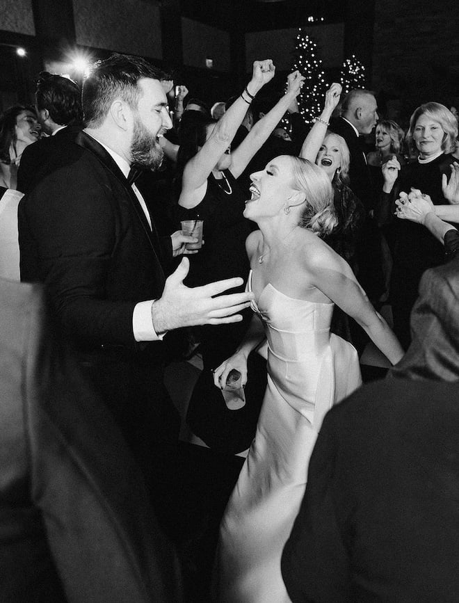 The bride and groom singing to each other on the dance floor. 