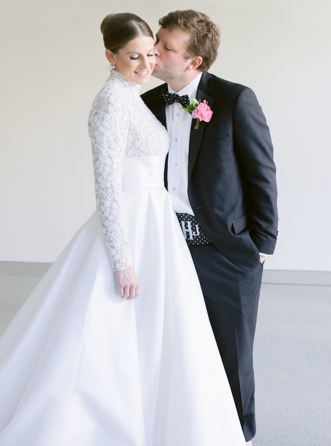 A groom kissing his bride on the cheek. 