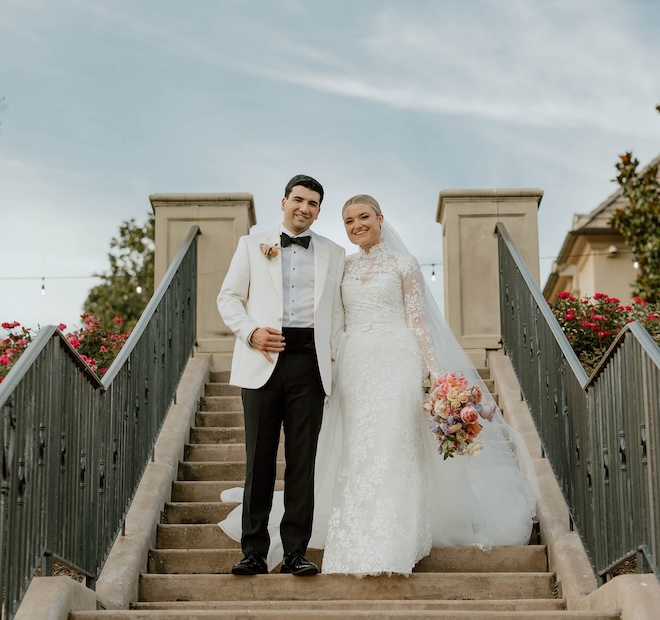 The bride and groom smiling on the steps of the Royal Oaks Country Club for their New Orleans-Inspired wedding. 