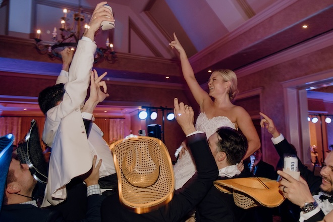 The bride and groom held up on chairs during their New Orleans style wedding reception. 