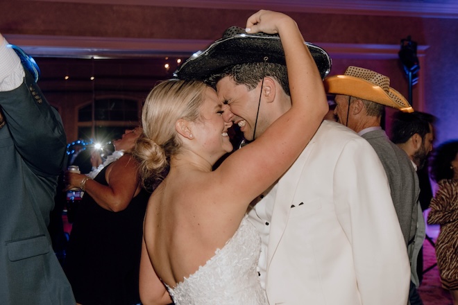 The bride and groom smiling with their foreheads pressed together during their New Orleans style wedding reception. 