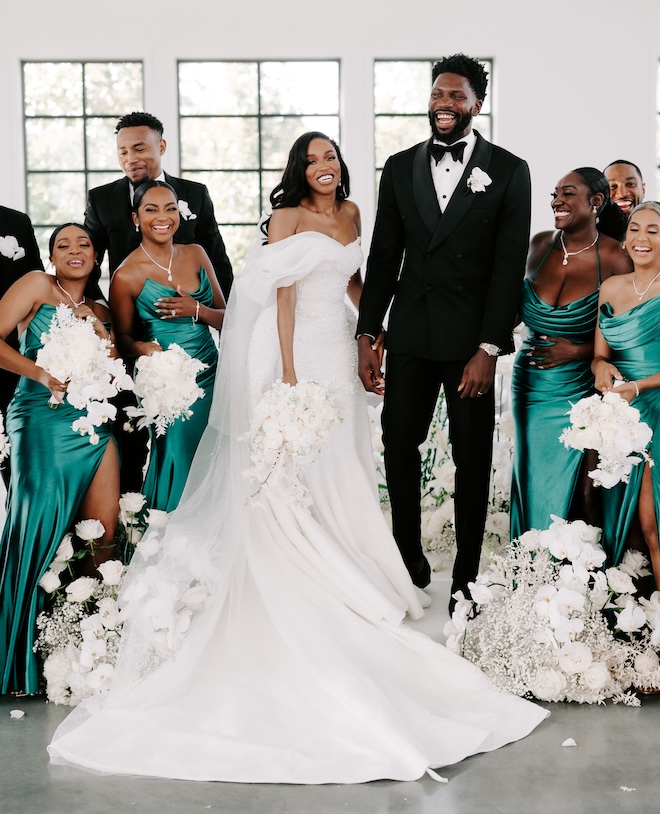 The bride and groom posing with their wedding party. 