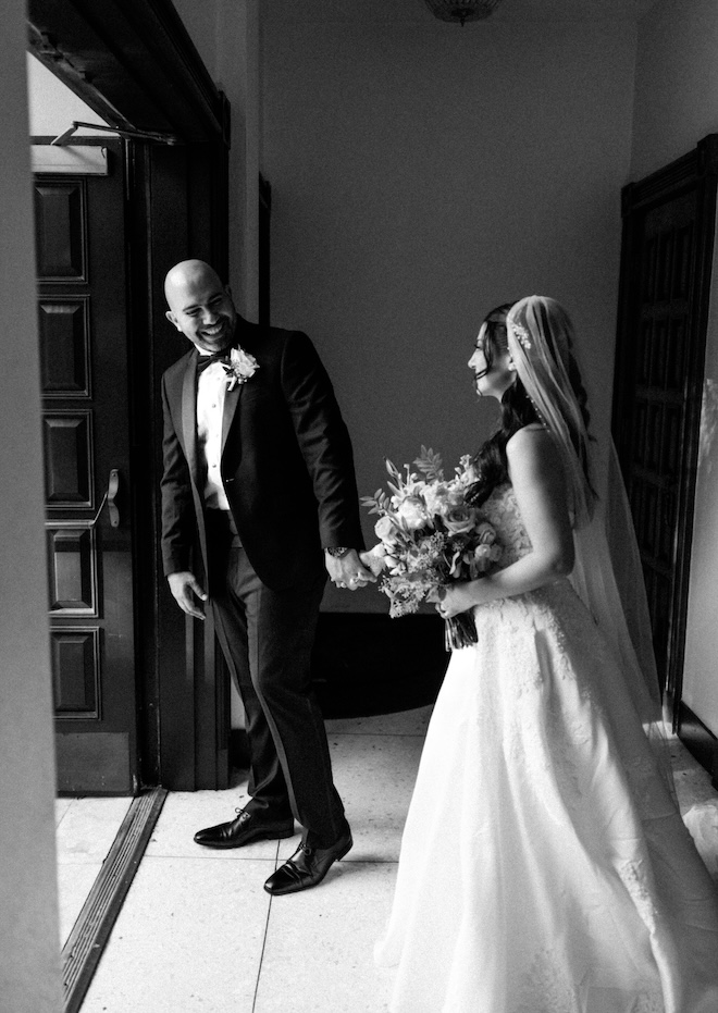 The bride and groom hold hands after their first look. 