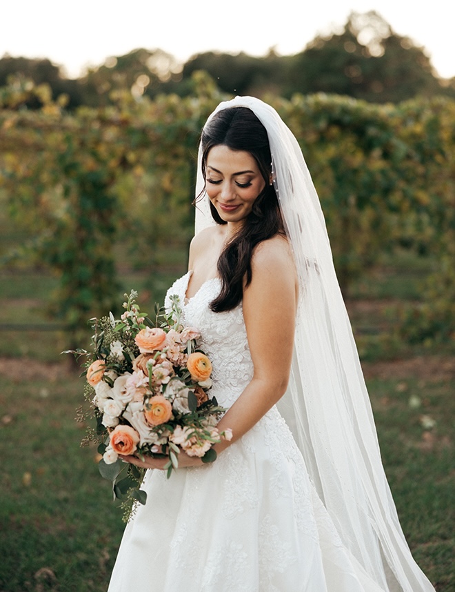 The bride holds her wedding bouquet outside her wedding venue.