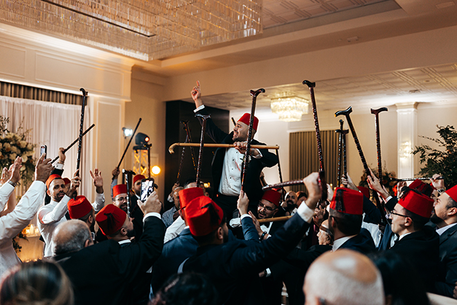 To honor his heritage, the groom does a traditional stick dance at the wedding reception.