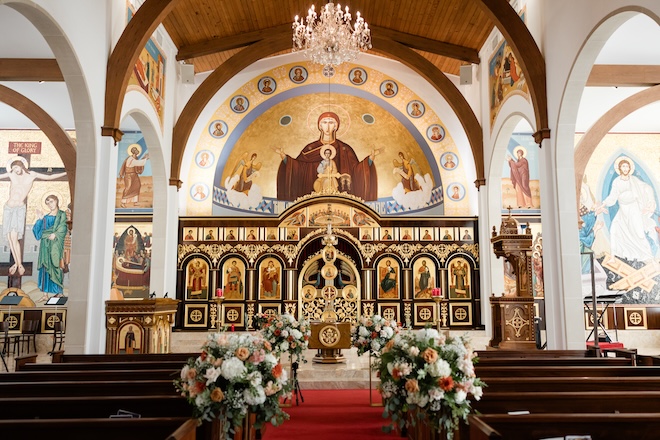 The aisle at the church ceremony is detailed in pastel floral arrangements. 