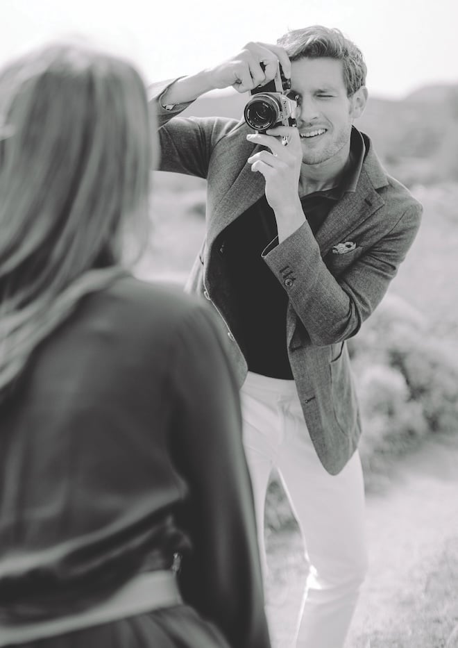 A man holding up a camera taking a photo of his new fiance. 