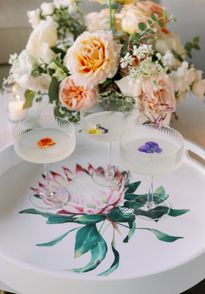 Custom cocktails are placed on a white serving tray during the wedding reception.