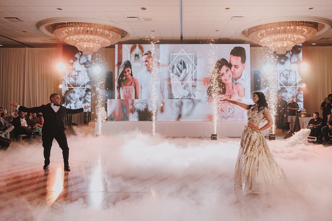 A bride and groom dancing with sparklers behind them in the ballroom of the Westin Galleria Houston. 