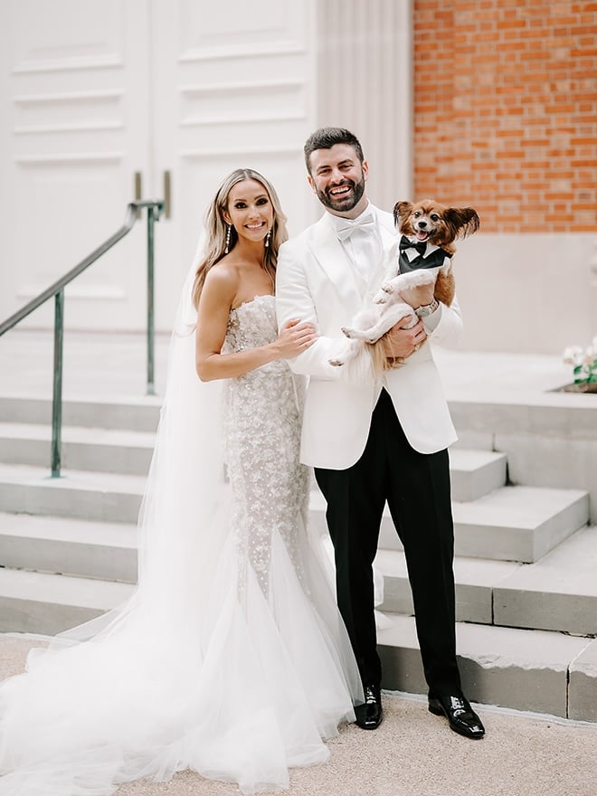 The couple smile outside the church with their dog after their wedding ceremony in Houston. 