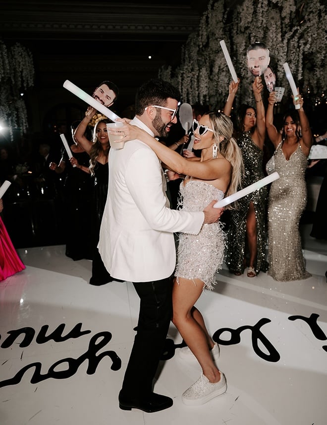 The bride and groom share a dance on the dance floor at their reception. 