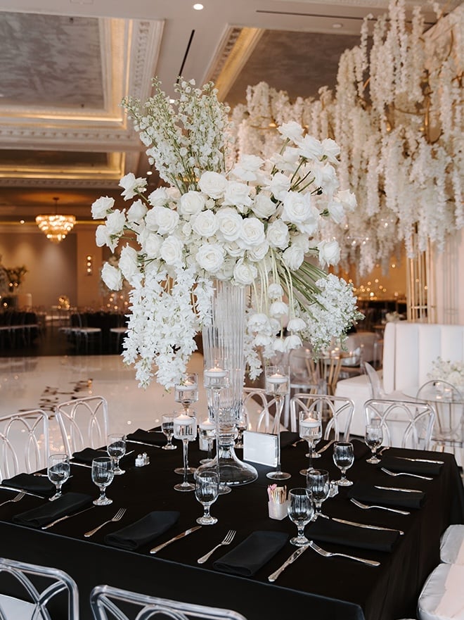 A variety of white flowers are placed on the reception tables at this chic Houston wedding.