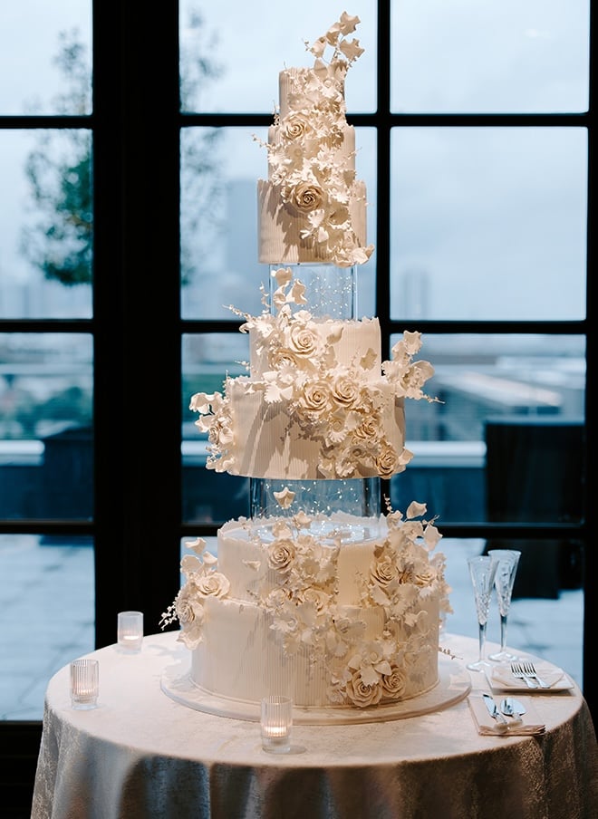 A nine tier wedding cake with acrylic tiers is the focal point of the chic Houston wedding.