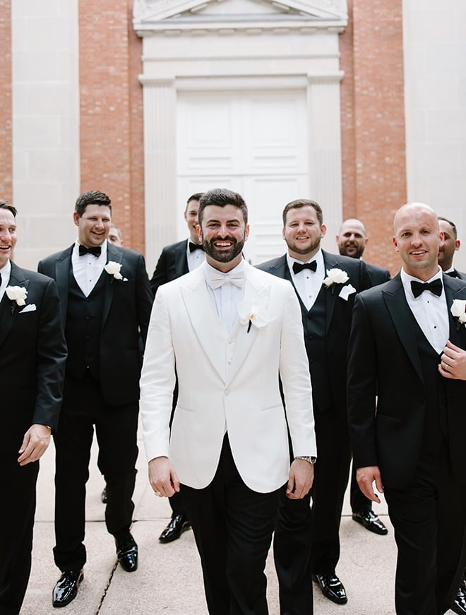 The groom and his groomsmen walk outside their church wedding venue in Houston. 