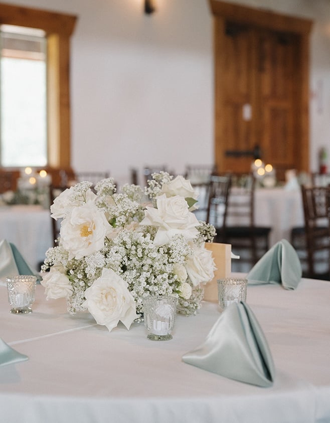 White roses and baby's breath decorate the reception tables.