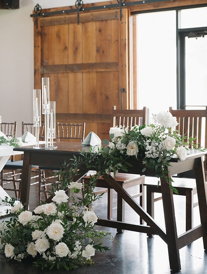 Greenery and white roses detail wedding reception. 