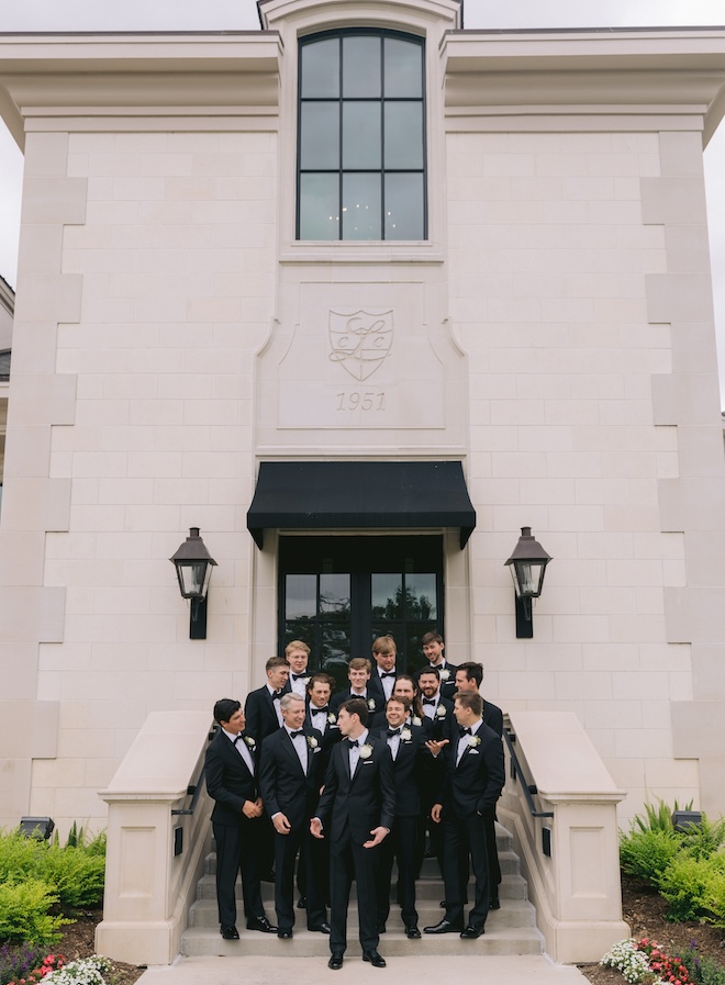 The groom and his wedding party standing on the steps of Lakeside Country Club. 