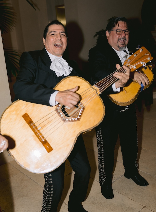 Two mariachi players with their guitars. 