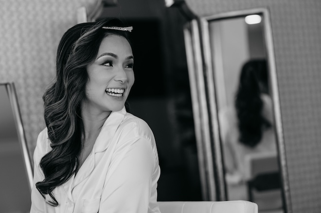 The bride smiling while getting her hair done. 