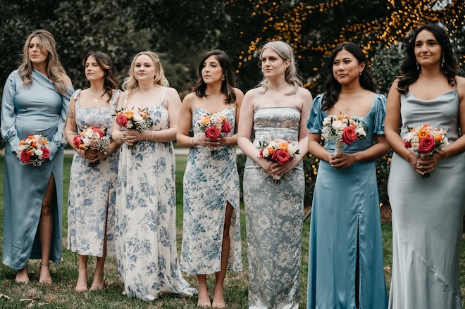 The bridesmaids in different blue and blue floral print dresses. 