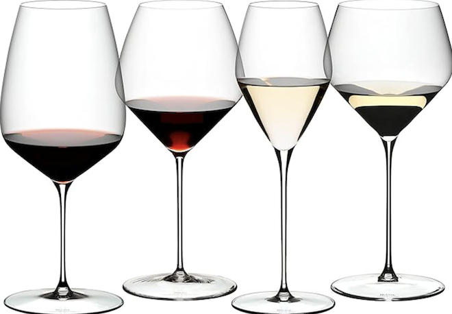 Four different wine glasses with various stem sizes, shapes and wine colors in them. 