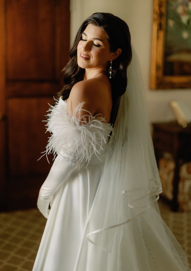 The bride wears feathered gloves for her wedding ceremony in Houston.