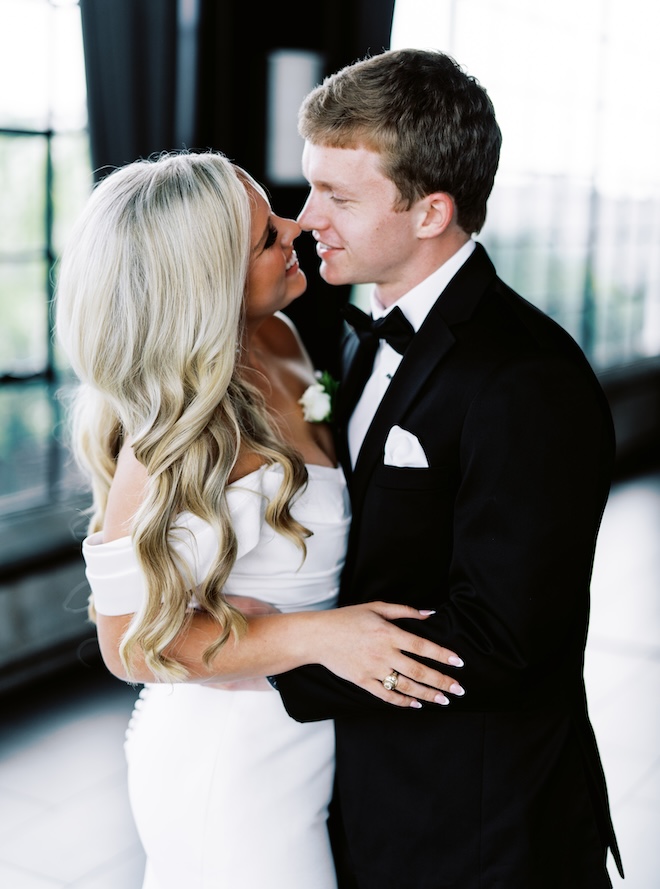 The bride and groom hugging and smiling with their noses touches. 