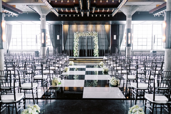 The ceremony space at the Astorian with a black and white aisle and a white floral altar. 