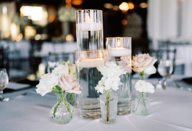 Floating candles and delicate white and blush florals decorating the table. 