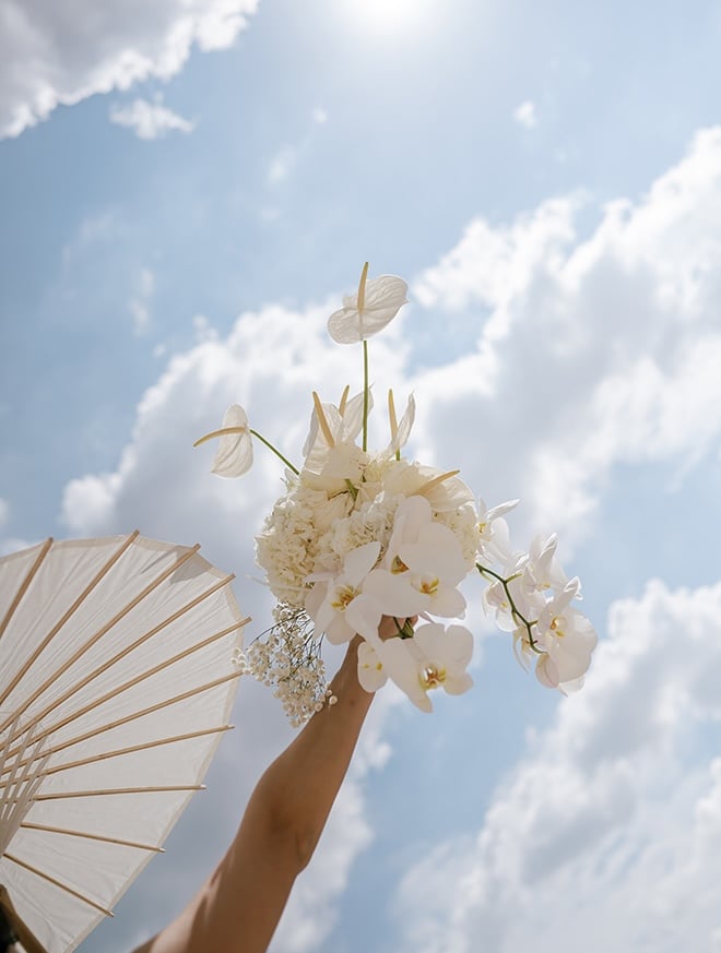 Beyond Bloems designs a wedding bouquet with white orchids, baby's breath and anthurium. 