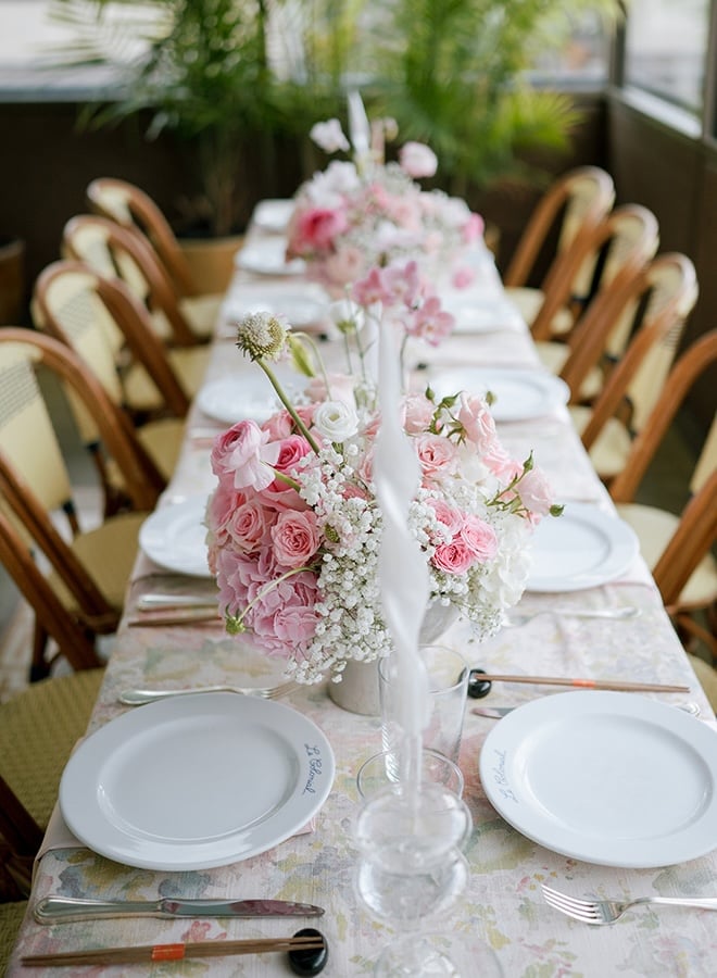 Floral arrangements of pink and white florals decorate the reception tables at a Houston restaurant wedding reception. 