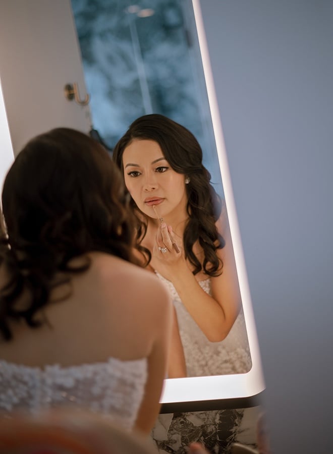 The bride applies her lipstick at the Thompson Houston, by Hyatt for her wedding day.