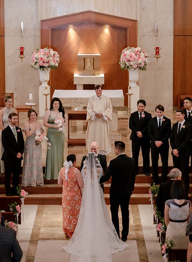 The mother of the bride and her brother walk her down the aisle at her church wedding ceremony in Houston.