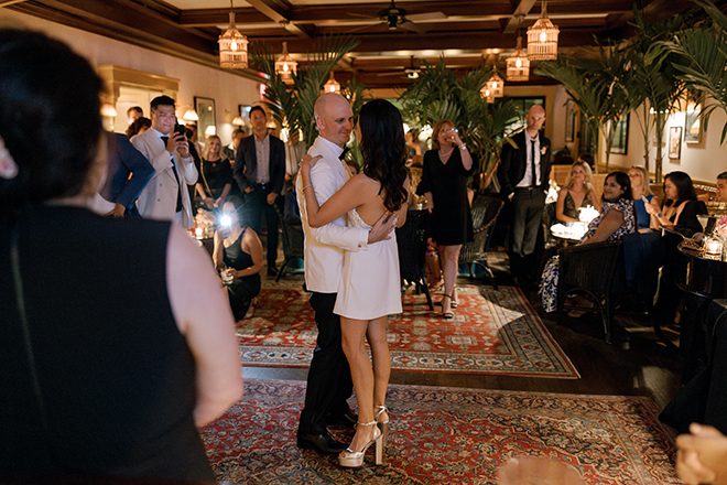 The bride and groom dance as wedding guests watch at their restaurant wedding reception at Le Colonial. 