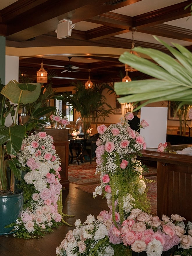 Pink florals, greenery and baby's breath decorate the restaurant wedding reception in Houston. 