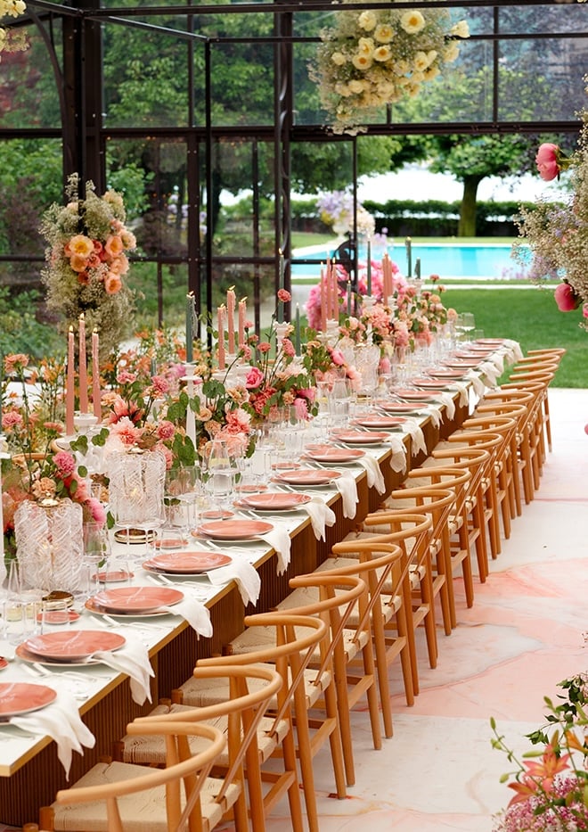 Pink taper candles, greenery and pink flowers decorate the family-style reception table. 