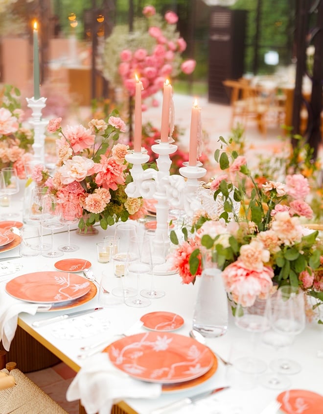 Pink taper candles and pink flowers detail the reception tables. 