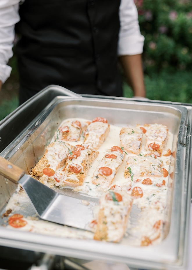 Atlantic salmon with lemon basil cream is served at a buffet. 