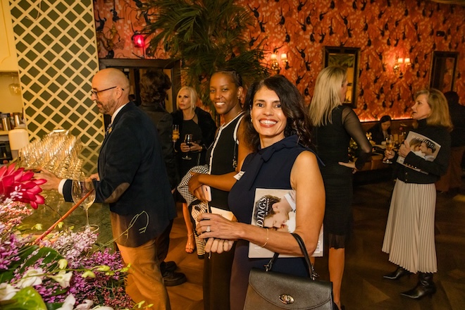 Guests smiling while standing at the bar. 