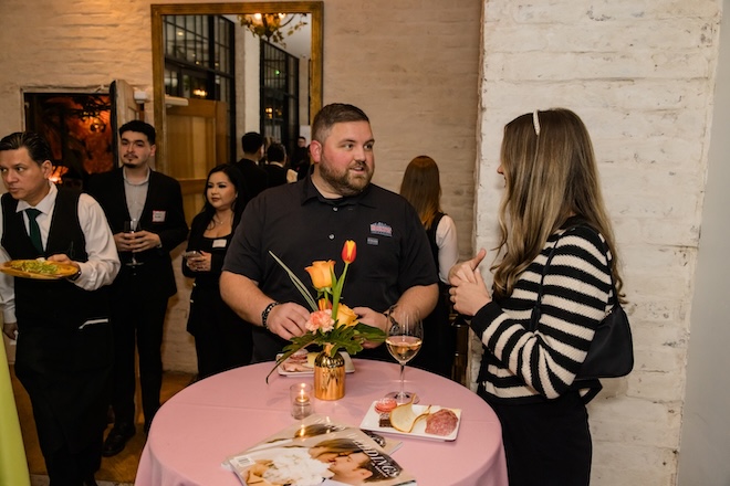 Guests chatting with wine and food. 