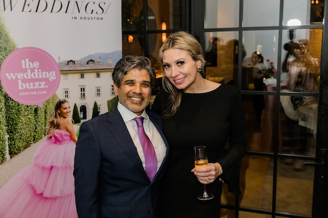 Our publisher, Vik Day, smiling with Lisa Hudson in front of The Wedding Buzz banner. 